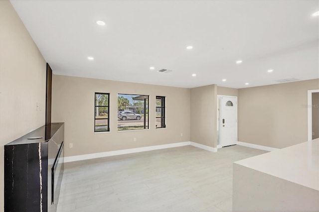 unfurnished living room with baseboards, visible vents, and recessed lighting