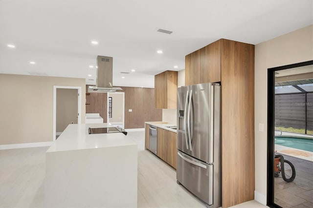 kitchen featuring brown cabinetry, island exhaust hood, modern cabinets, light countertops, and appliances with stainless steel finishes