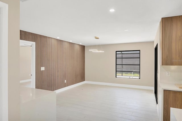 empty room with recessed lighting, light wood-type flooring, and baseboards