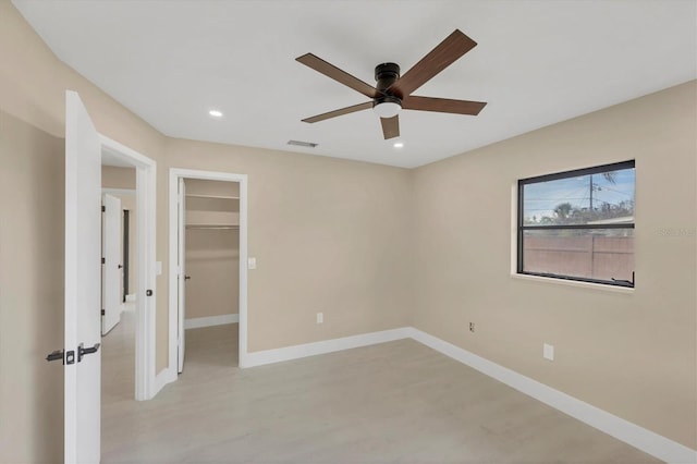 unfurnished bedroom featuring a spacious closet, baseboards, visible vents, and recessed lighting