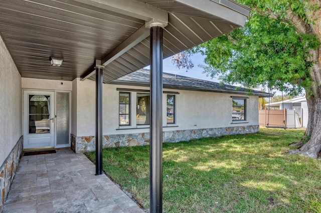 exterior space featuring stucco siding, fence, a yard, and a patio