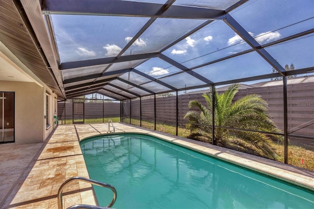outdoor pool with glass enclosure, a fenced backyard, and a patio