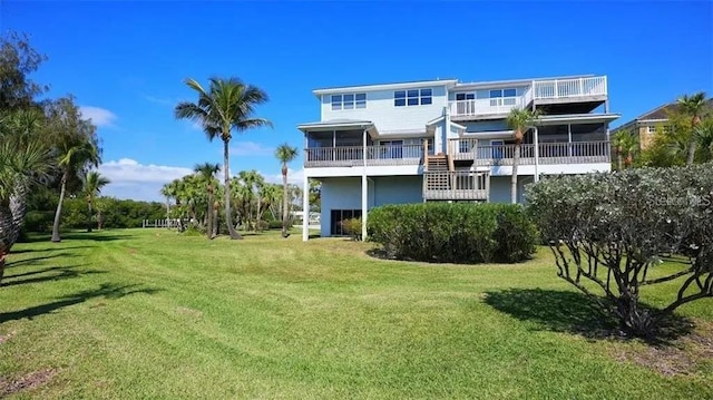 rear view of property with a sunroom, a yard, and a balcony