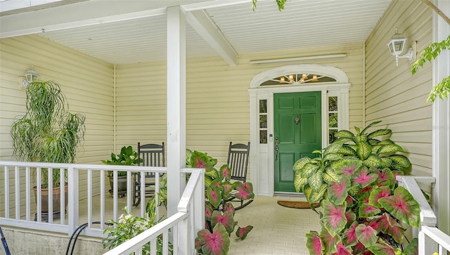 view of exterior entry featuring covered porch