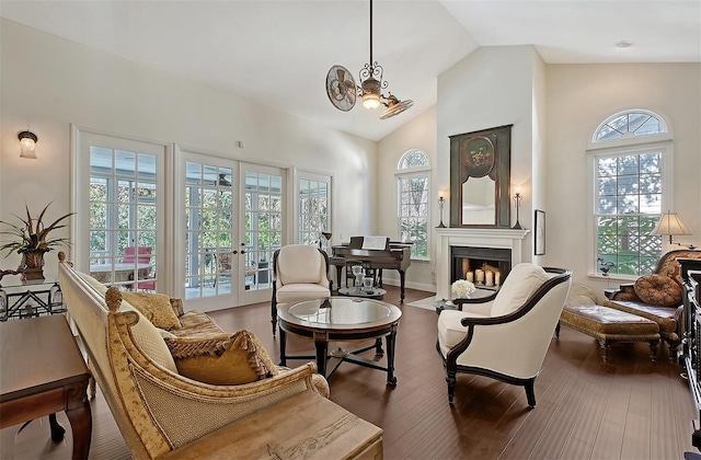 sitting room featuring french doors, a fireplace, a chandelier, and a healthy amount of sunlight
