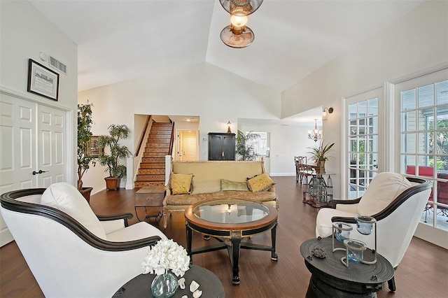 living area with visible vents, baseboards, an inviting chandelier, wood finished floors, and stairway