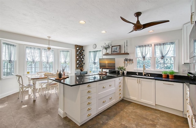 kitchen featuring black electric cooktop, plenty of natural light, a ceiling fan, and a sink