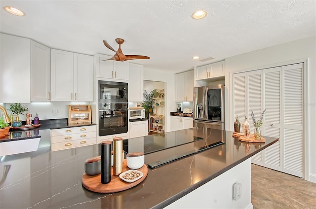 kitchen featuring black appliances, dark countertops, and white cabinets