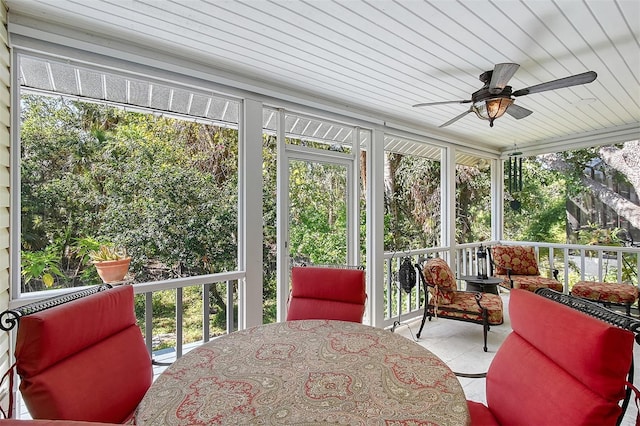 sunroom with a ceiling fan and outdoor dining space