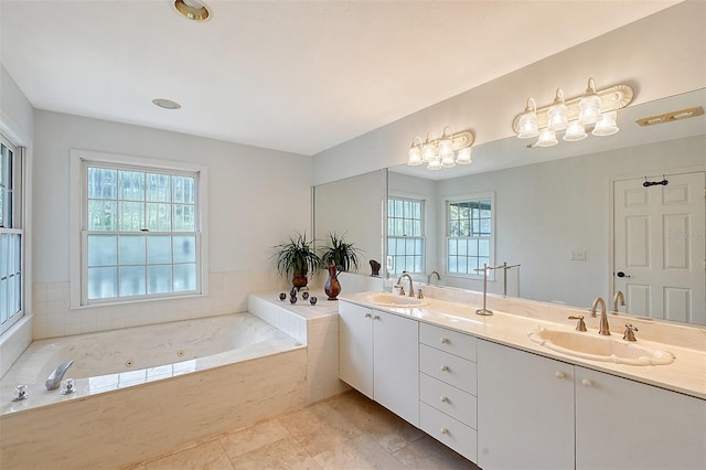 full bath featuring plenty of natural light, a jetted tub, and a sink