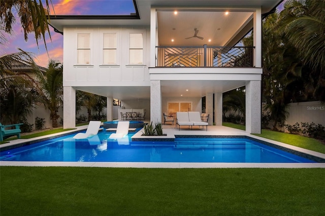 back of house with an outdoor living space, a patio, a balcony, and a yard