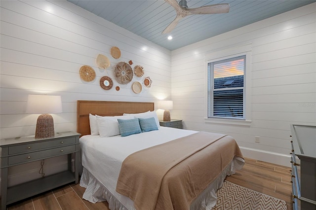 bedroom featuring recessed lighting, wooden walls, ceiling fan, and wood finished floors