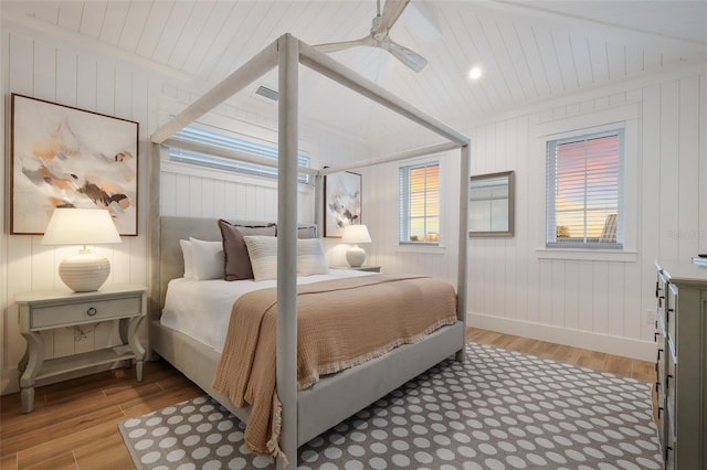 bedroom with multiple windows, baseboards, light wood-type flooring, and wood ceiling