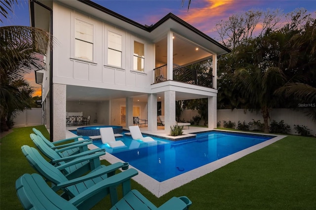 back of house featuring a yard, a fenced backyard, a patio, and a balcony