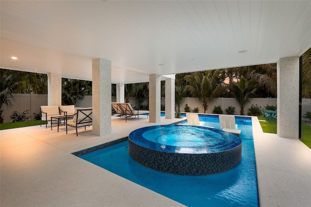 view of swimming pool featuring a fenced backyard, a pool with connected hot tub, and a patio area