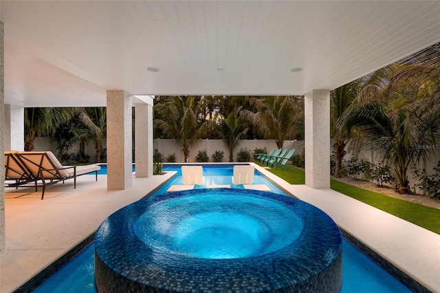 view of pool featuring a fenced backyard, a pool with connected hot tub, and a patio area