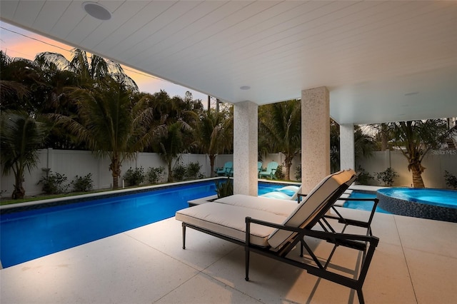 view of pool featuring a patio area, a fenced backyard, and a pool with connected hot tub