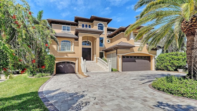 mediterranean / spanish home featuring an attached garage, decorative driveway, stucco siding, and a balcony