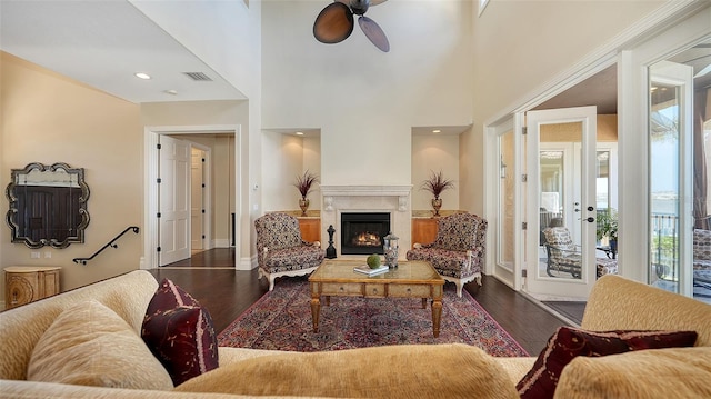 living room featuring visible vents, a ceiling fan, dark wood finished floors, and plenty of natural light
