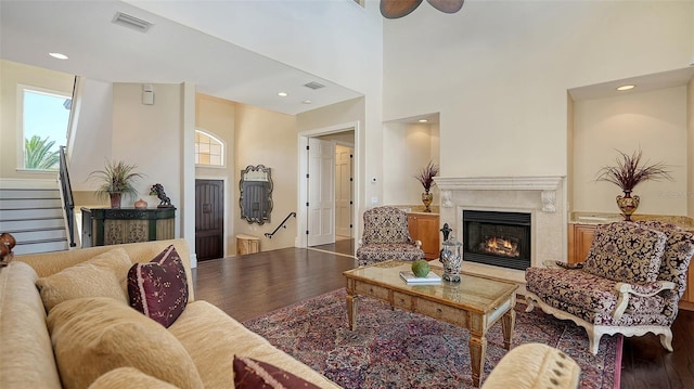 living room featuring visible vents, a high end fireplace, wood finished floors, and stairway