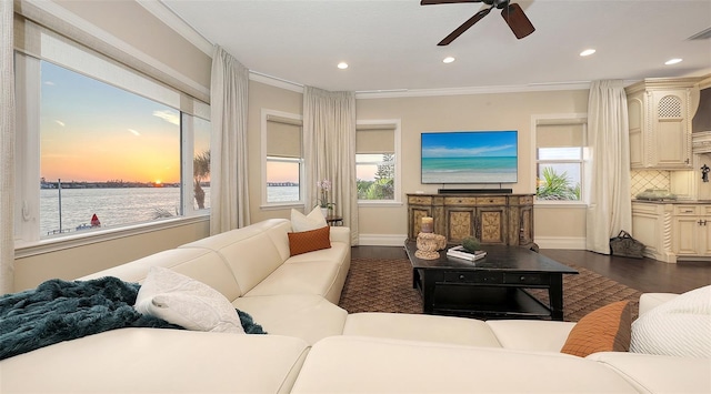 living area featuring a ceiling fan, crown molding, dark wood finished floors, baseboards, and recessed lighting