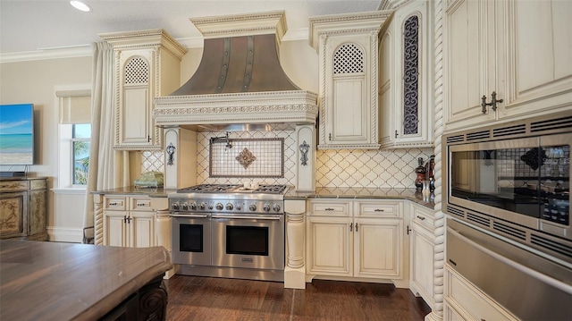 kitchen featuring appliances with stainless steel finishes, custom range hood, a warming drawer, and cream cabinetry