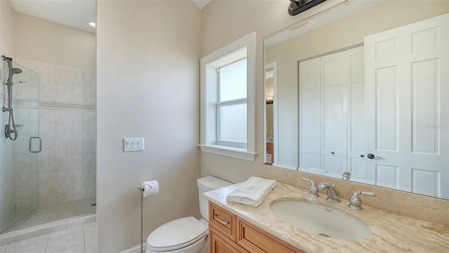 bathroom with tile patterned flooring, a stall shower, vanity, baseboards, and toilet
