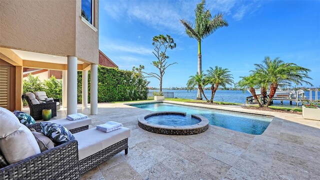 view of swimming pool featuring a water view, a patio area, a pool with connected hot tub, and an outdoor hangout area