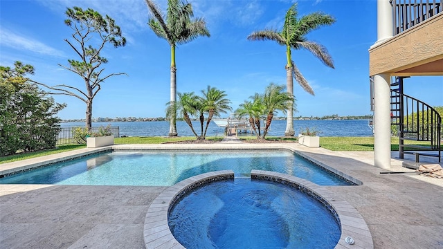 view of pool featuring a patio, a water view, a pool with connected hot tub, and stairway