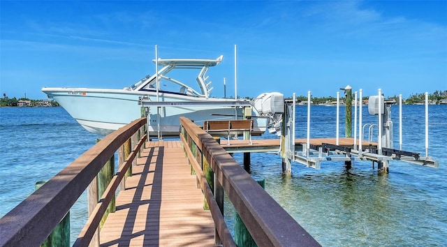 view of dock with boat lift and a water view