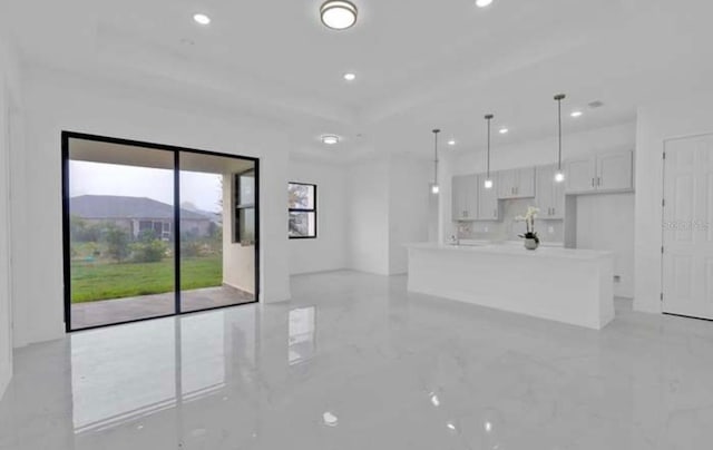 unfurnished living room with recessed lighting and marble finish floor