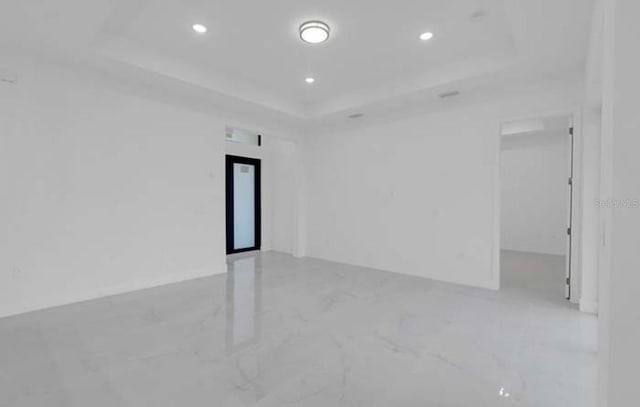 spare room featuring recessed lighting, a raised ceiling, elevator, and marble finish floor