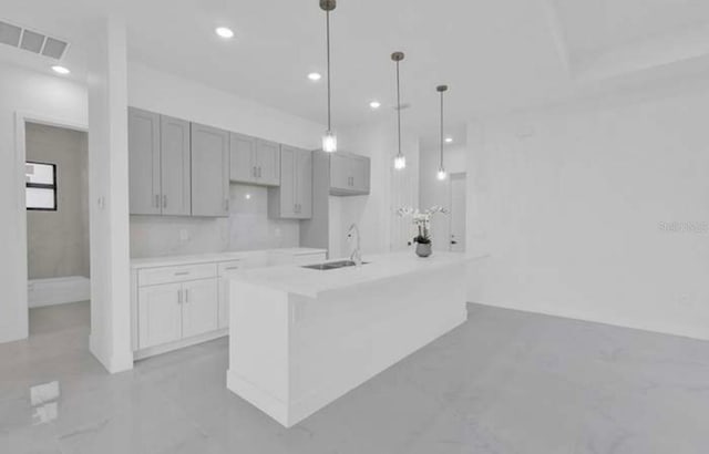 kitchen featuring a sink, visible vents, gray cabinetry, recessed lighting, and a kitchen island with sink