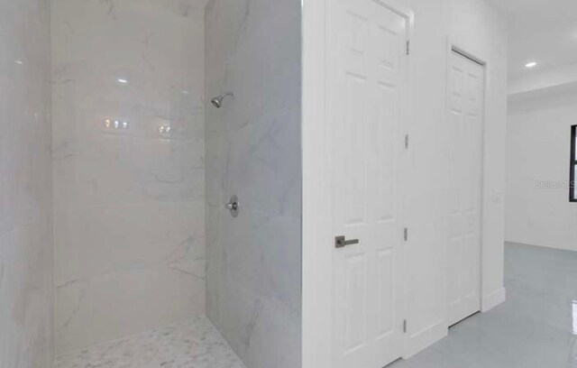 bathroom with recessed lighting and a marble finish shower