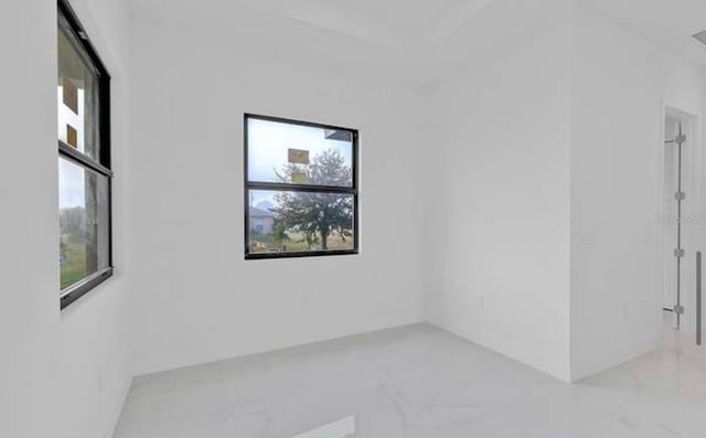 spare room featuring marble finish floor