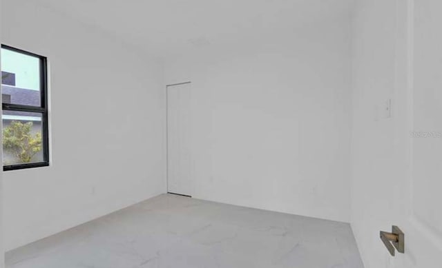 unfurnished room featuring marble finish floor