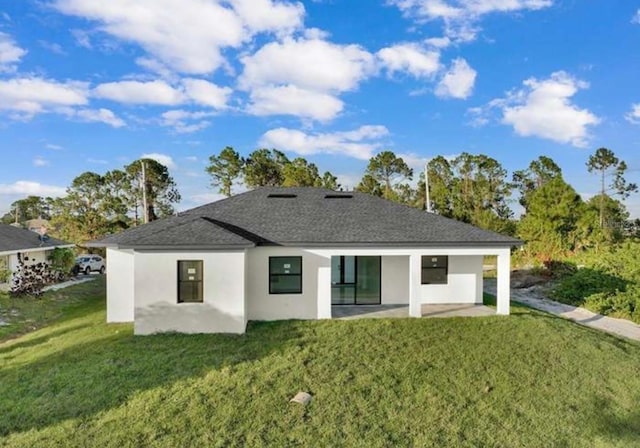 rear view of house with a patio, stucco siding, and a yard