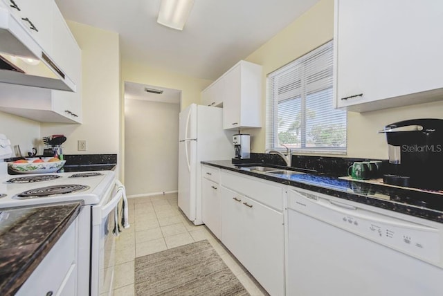 kitchen with white appliances, a sink, under cabinet range hood, white cabinetry, and dark stone countertops