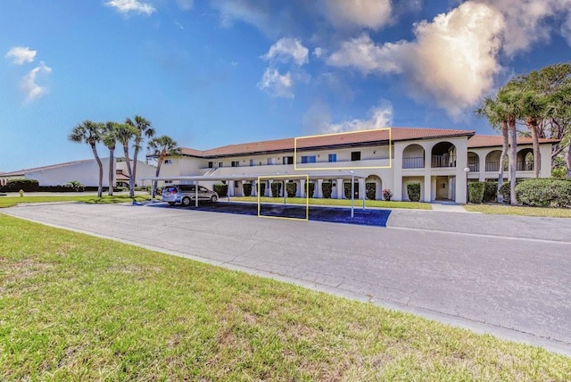 view of property with covered and uncovered parking