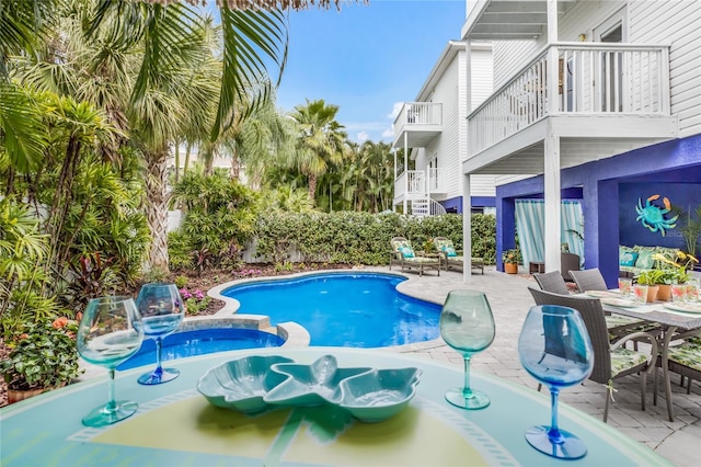 view of swimming pool featuring a pool with connected hot tub, outdoor dining space, and a patio