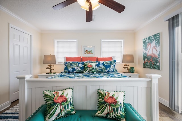 bedroom with multiple windows, wood finished floors, and ornamental molding