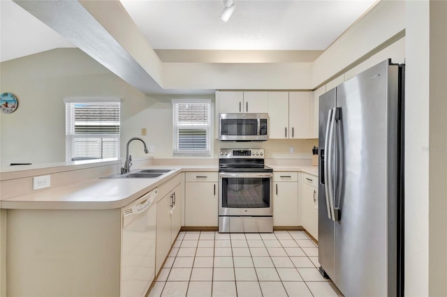 6415 39th Ave W, Bradenton, FL 34209 - kitchen with appliances with stainless steel finishes, a sink, light tile patterned floors, light countertops, and a peninsula