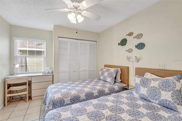 6415 39th Ave W, Bradenton, FL 34209 - bedroom with a ceiling fan, a textured ceiling, light tile patterned floors, and a closet