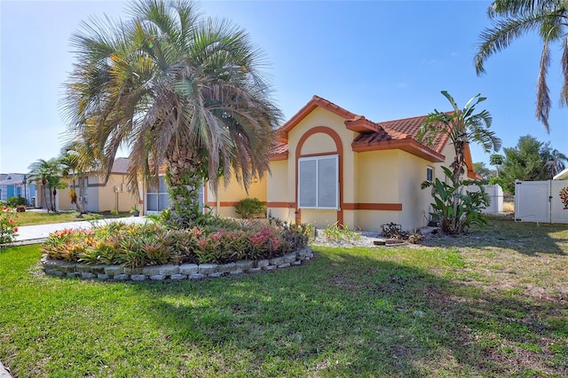 6415 39th Ave W, Bradenton, FL 34209 - view of property exterior featuring a tiled roof, a gate, stucco siding, and a yard