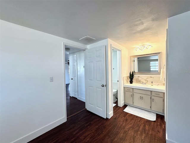 9430 Glen Moor Ln, Port Richey, FL 34668 - bathroom featuring wood finished floors, toilet, vanity, and baseboards