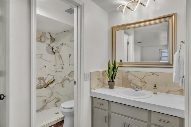 9430 Glen Moor Ln, Port Richey, FL 34668 - bathroom with vanity, a marble finish shower, a chandelier, toilet, and tile walls