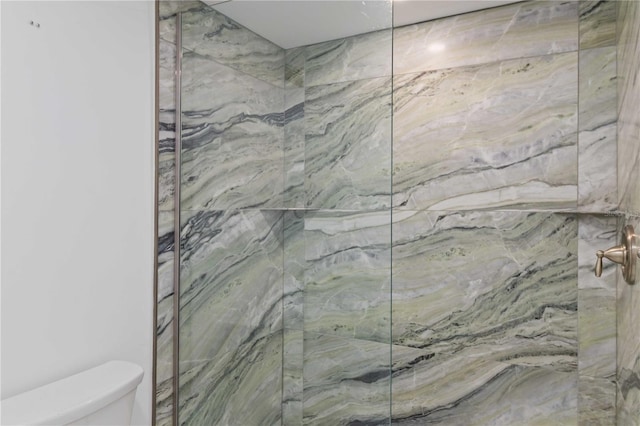 full bath featuring a marble finish shower and toilet
