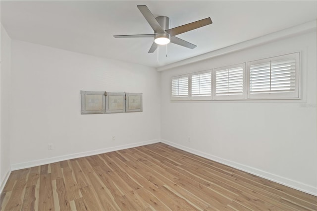 spare room featuring light wood-style flooring, baseboards, and a ceiling fan