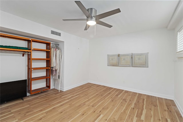 unfurnished bedroom featuring visible vents, baseboards, a closet, ceiling fan, and wood finished floors