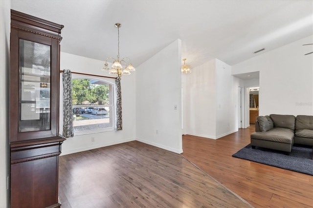 living room with wood finished floors, a chandelier, baseboards, visible vents, and lofted ceiling